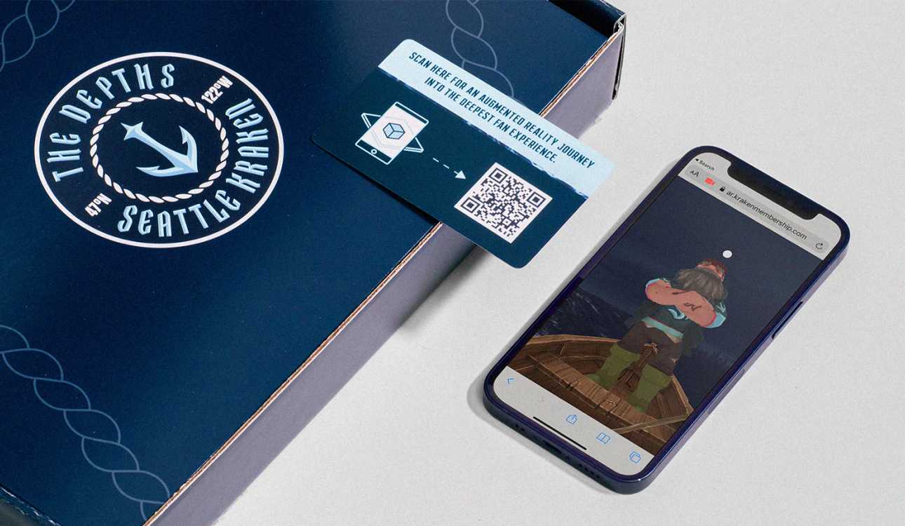 An open Seattle Kraken kit revealing a QR code. A phone has followed the QR code to an animated scene of a sailor wearing a Kraken jersey.